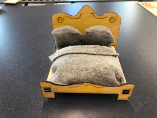 Aquí hay una cama diseñada por un estudiante, cortada de abedul báltico en el cortador láser, y el estudiante usó sus habilidades de costura para crear el colchón, la manta y las almohadas.
