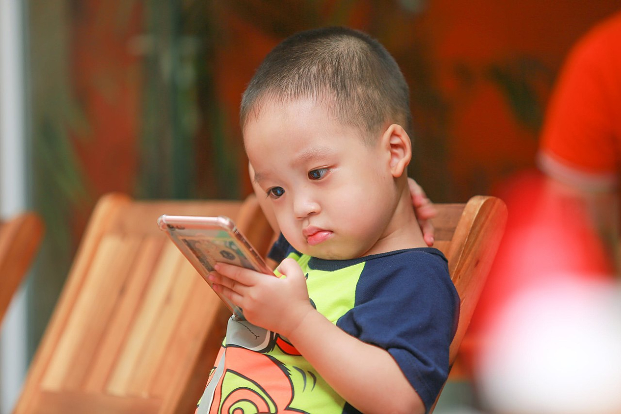 Fotografía de un niño con un smartphone (Foto: Kaku Nguyen)