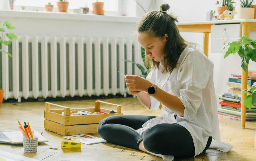 Fotografía de un aula con una alumna realizando tareas.