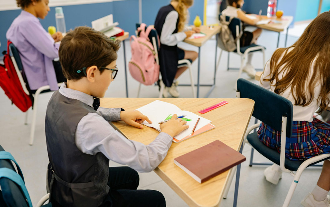 Fotografía de un aula con alumnos realizando tareas.